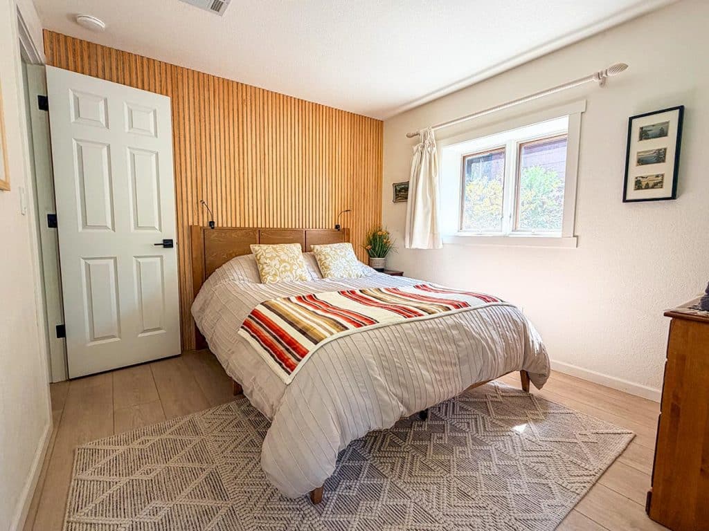 Queen bedroom with wood accent wall at Boom Chalet