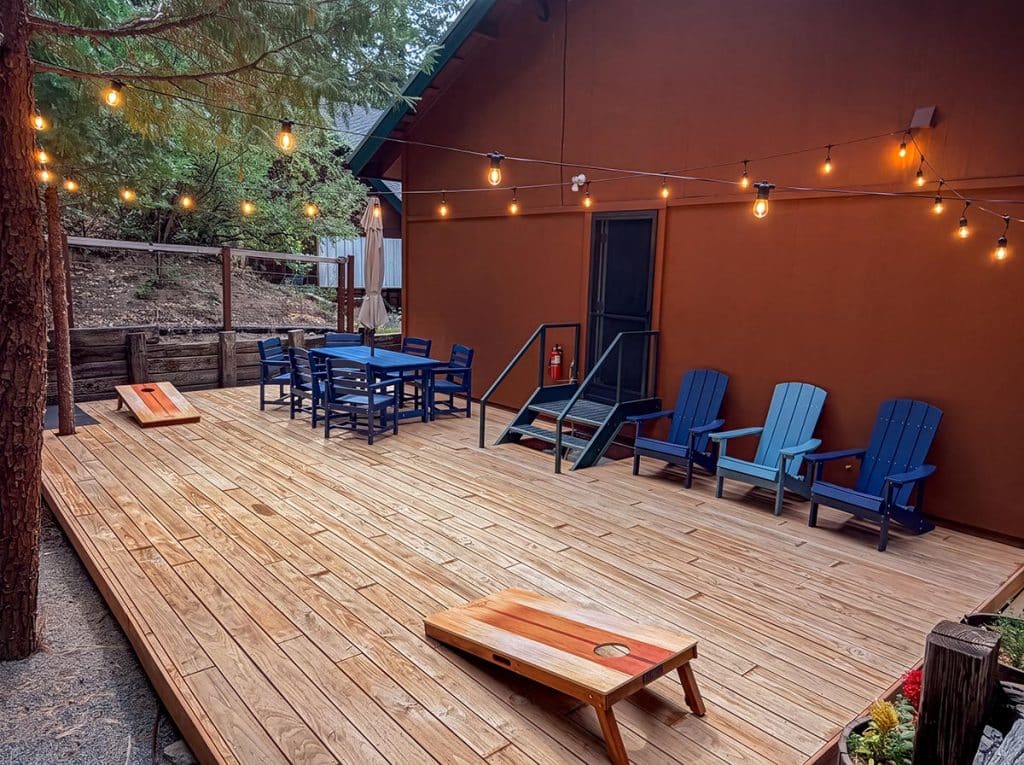Private back deck with string lights and Adirondack chairs at Boom Chalet