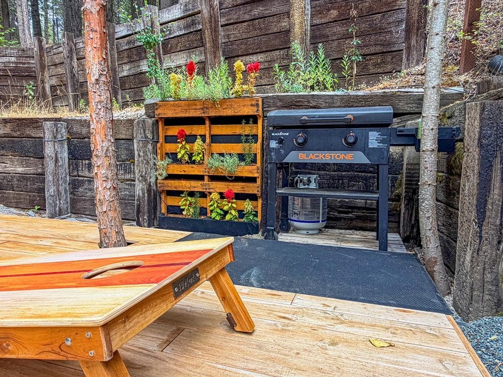 Back deck Blackstone griddle and cornhole board at Boom Chalet
